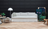 Sofá Venice con asiento continuo y faldón hasta el suelo, en salón. Fotografía de ambiente de Joquer.