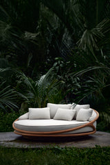 Cama lounge de jardín Solis de Ethnicraft, junto a vegetación tropical